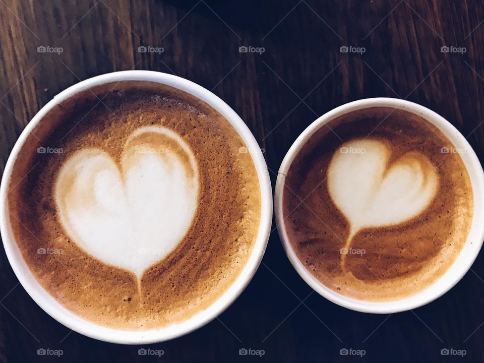 Closeup of two cappuccinos with heart shaped milk foam 