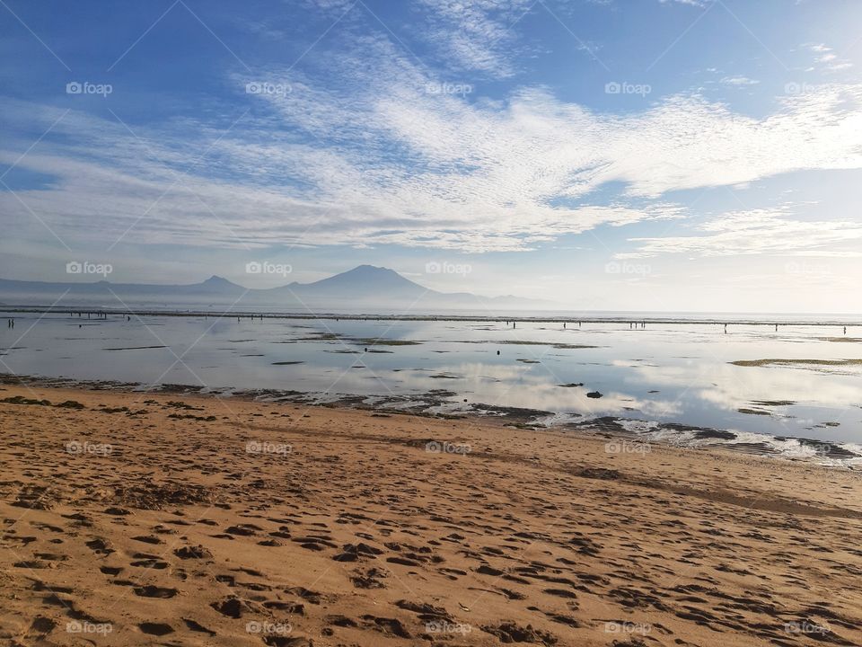 a calm vibe of a white sand beach in the morning