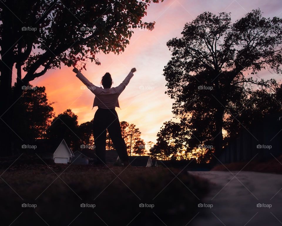 Woman admires the sunset at blue hour.