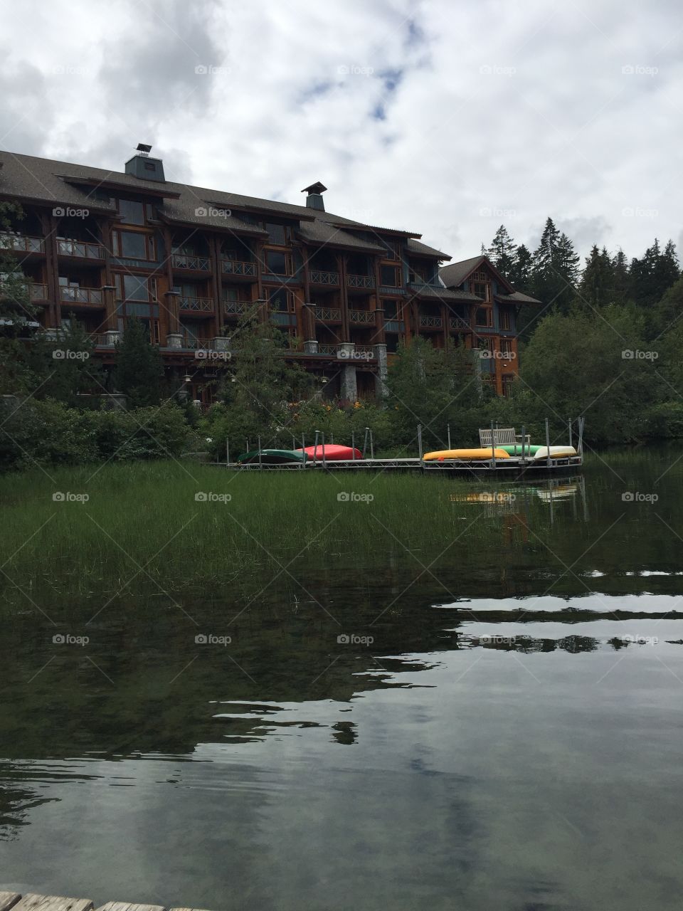 Coloured canoes off the dock waiting to be used at Nitka Lake in Whistler, British Columbia