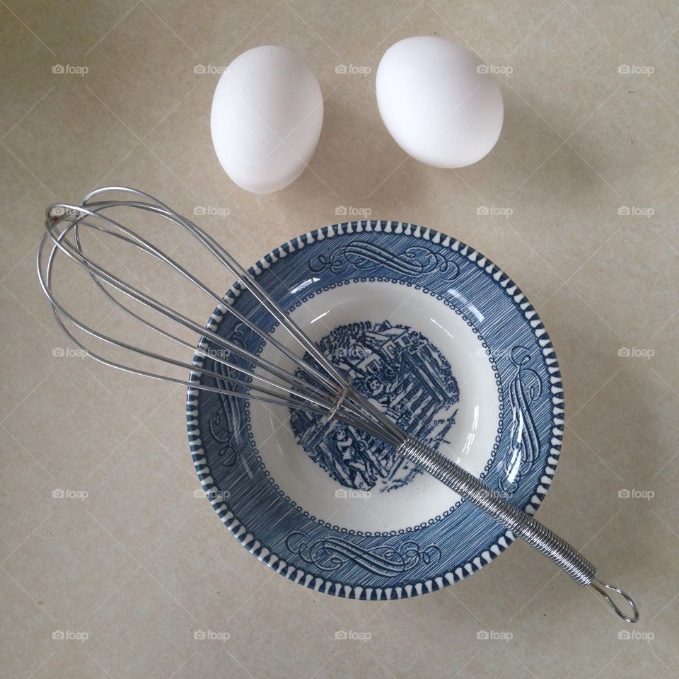 High angle view of egg and wire whisk