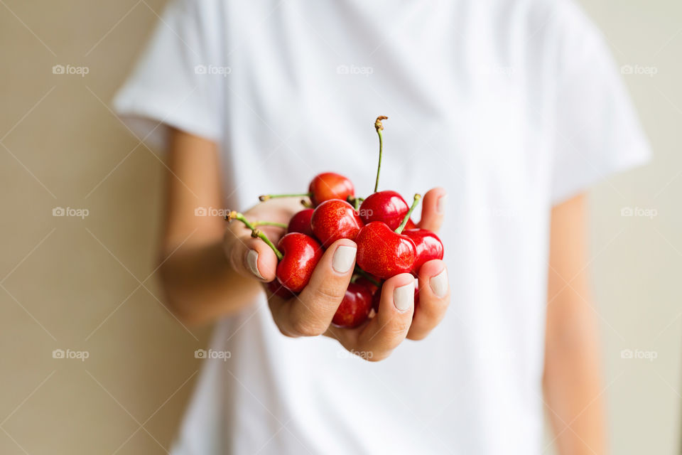 Woman hand holding fresh cherries 