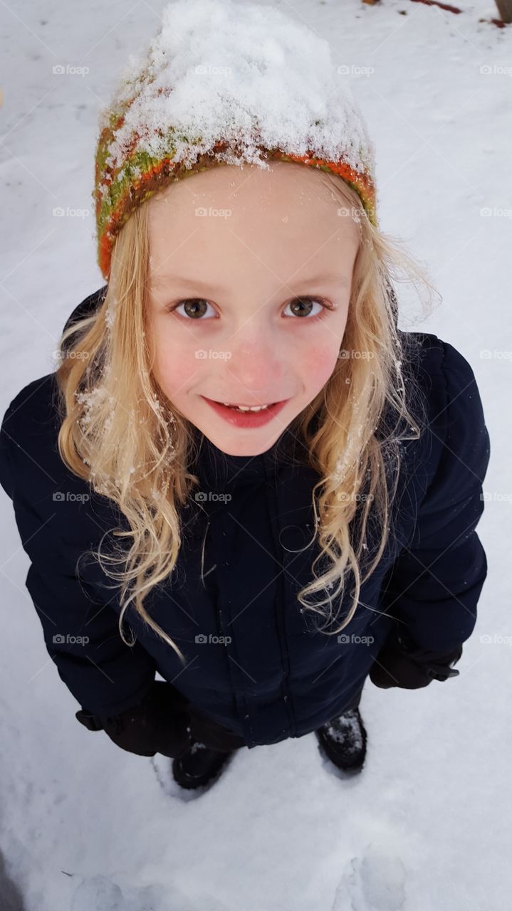 smiling child in winter gear in the snow