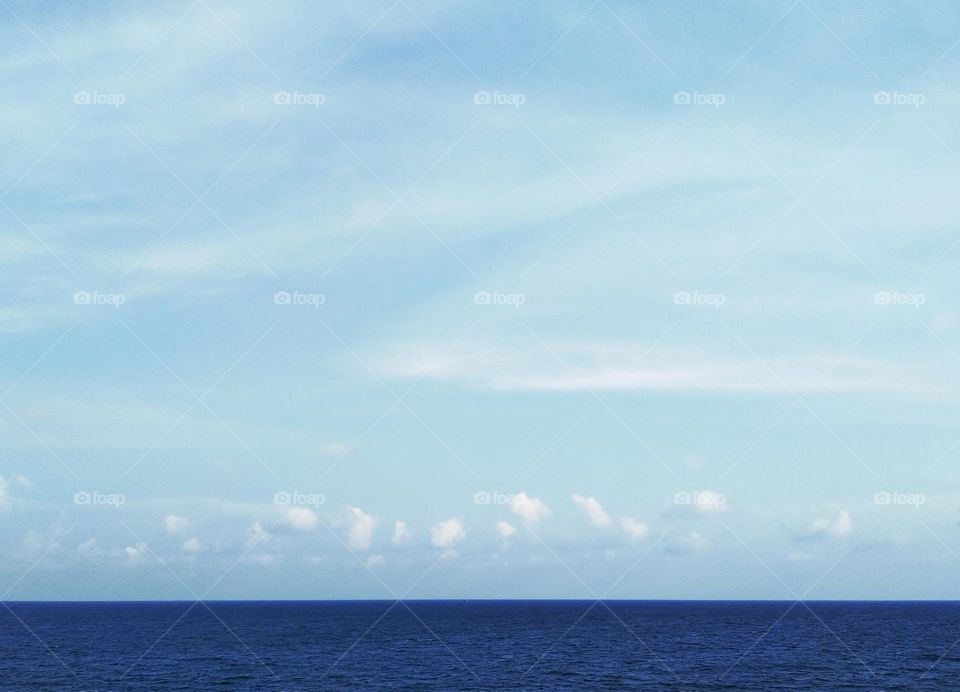 Cloudscape on the sea, the "Z" of cirrostratus clouds decorates the blue sky.