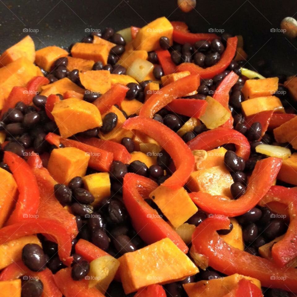 Sautéed bell pepper,squash and black beans  in a sauté pan 