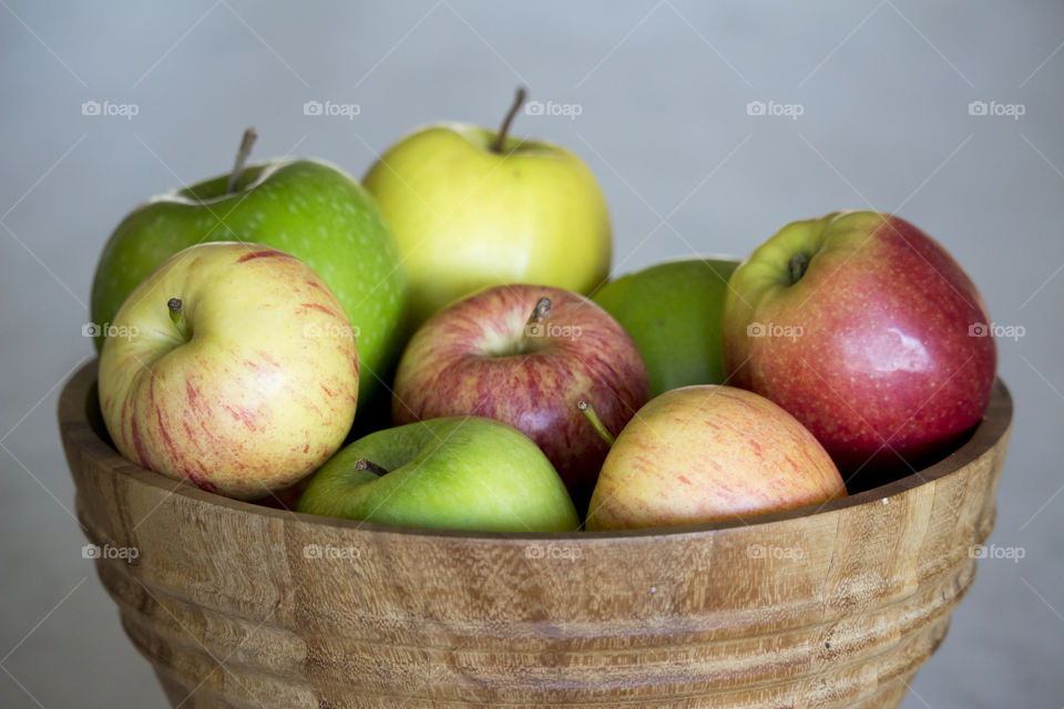 Apples different colors in wood bowl 