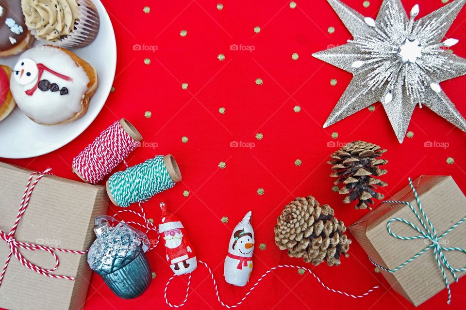 Red polka dots table cloth with Christmas themed doughnuts , chocolates and deco 
