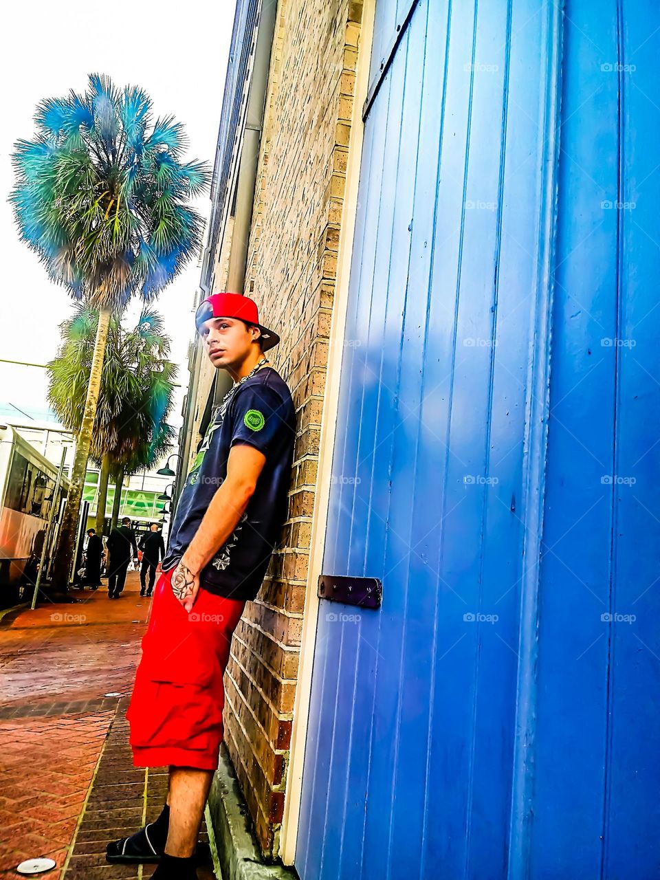 New Orleans Louisiana a man standing outside on a brick wall surrounded by palm trees