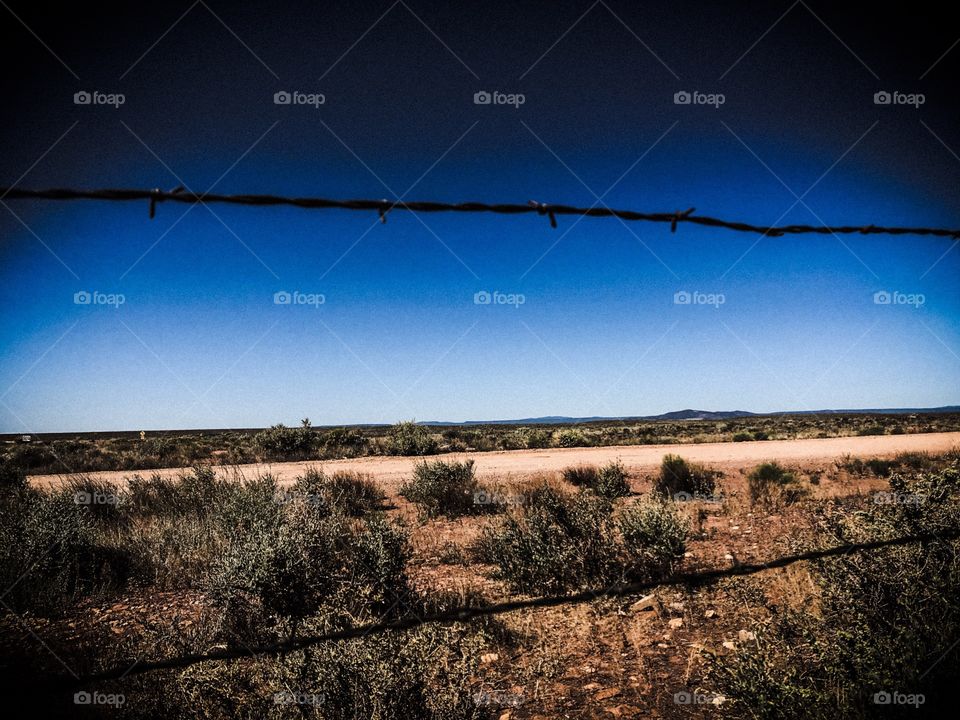 View of the desert through barbed wire fence, Arizona