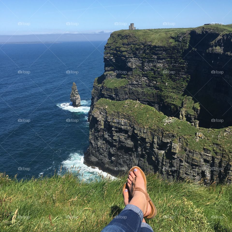 Don’t fall! Relaxing at the edge of a cliff at Ireland’s natural wonder - the Cliffs of Moher