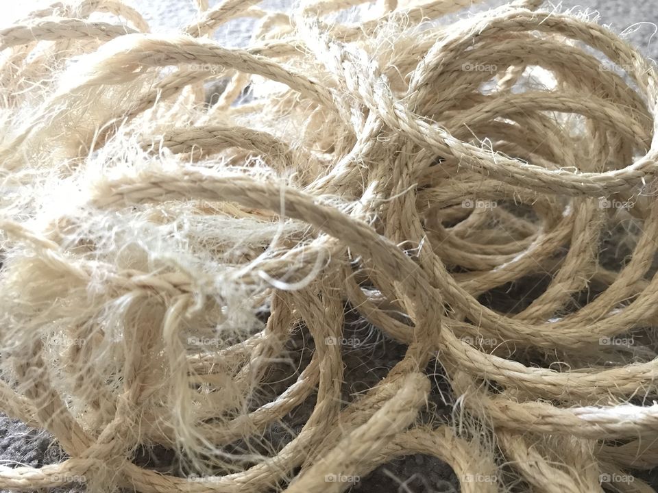 Horizontal picture of frayed worn rope. It’s unorganized, messy, and old. 