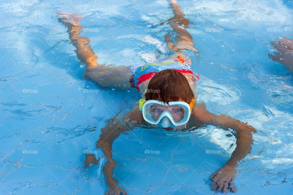 A boy has fun in shallow swimming pool