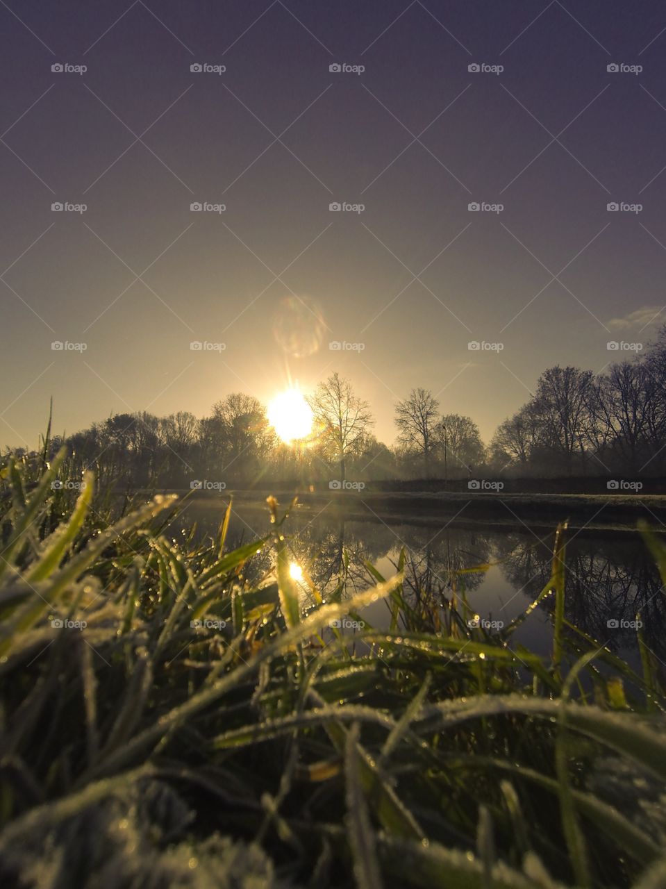 Countryside sunrise showing the colorful sky reflected in the water of the river 