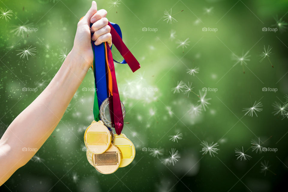 A hand holding medals