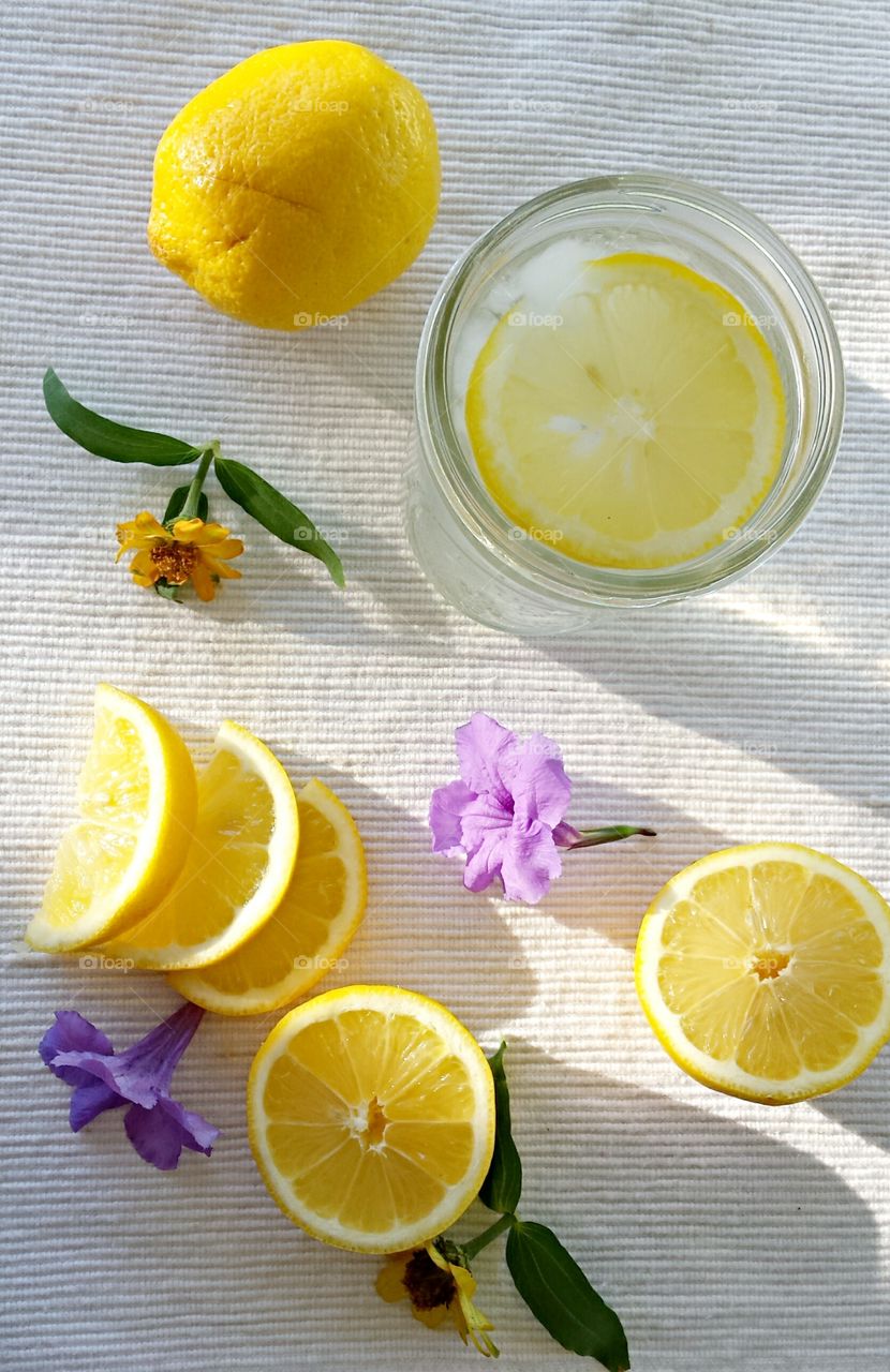Water with lemon and purple flowers