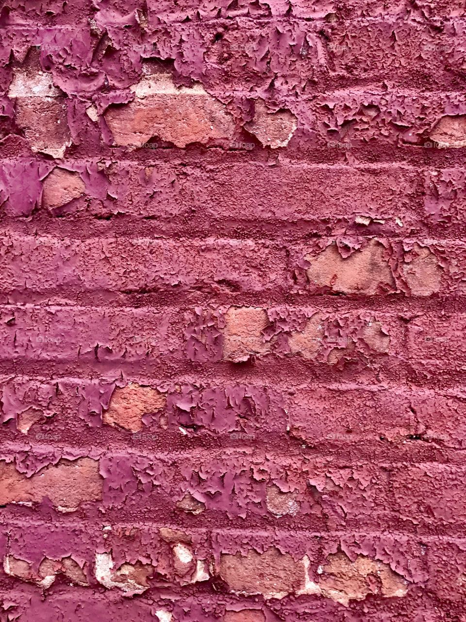 Peeling paint on brick wall