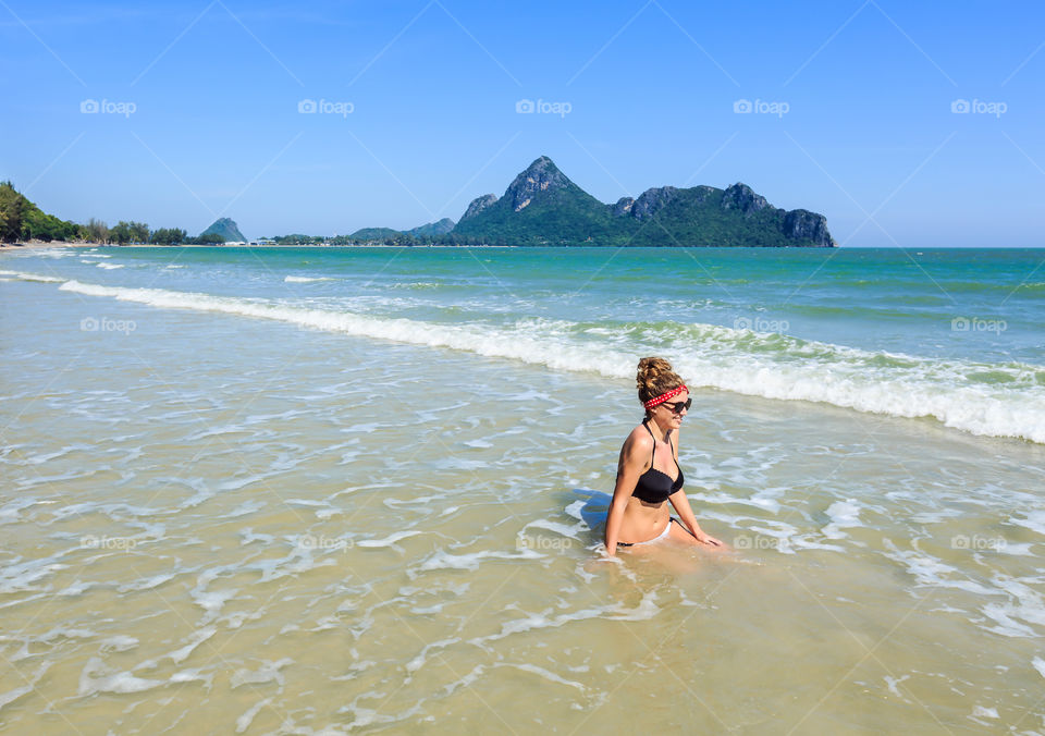 Beautiful fashionable young female person enjoying on sandy beach 