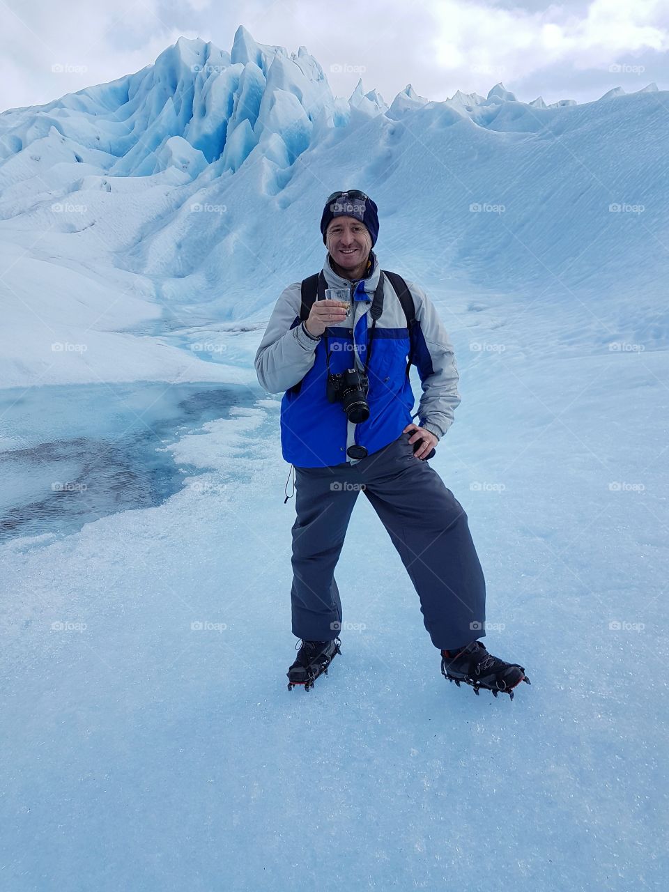 Man standing on snow holding glass of water