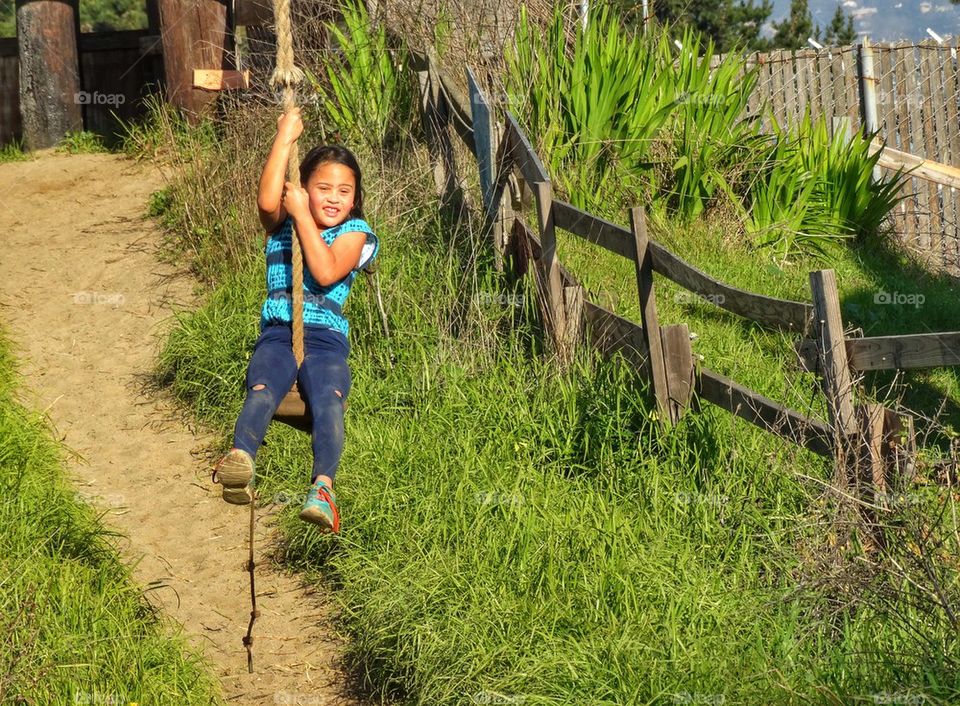 Happy Girl Swinging On A Zipline. Girl Swinging On A Treehouse Zipline
