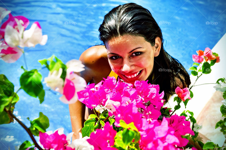 Woman with flowers in a pool, smiling, portrait