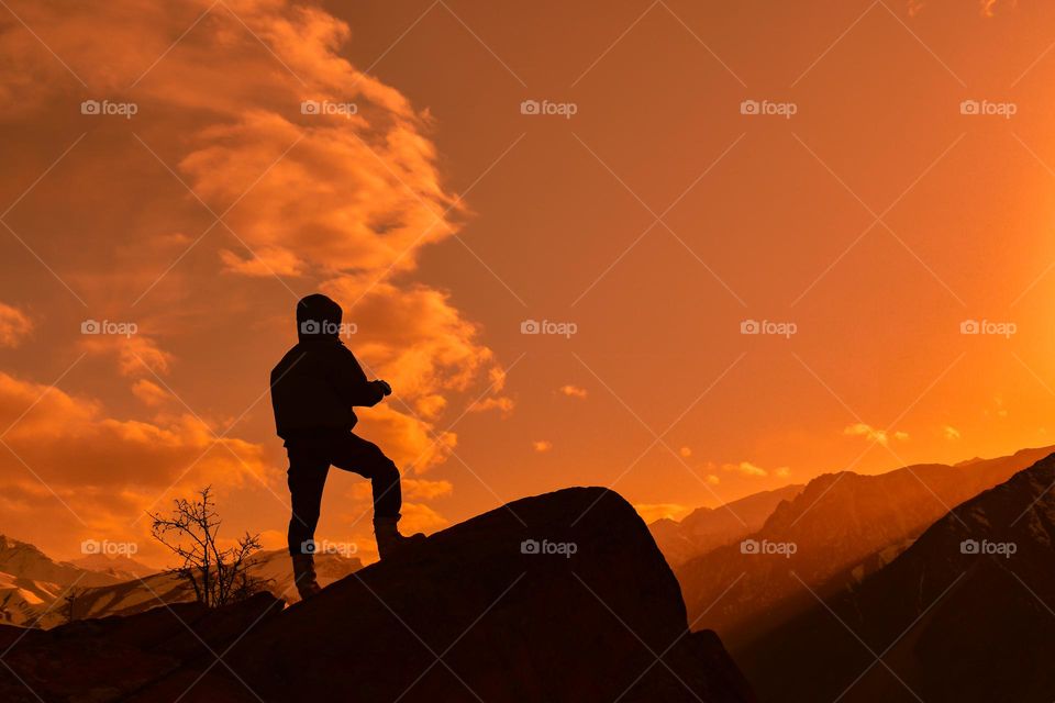 silhouette of a standing man on the top of a hill
