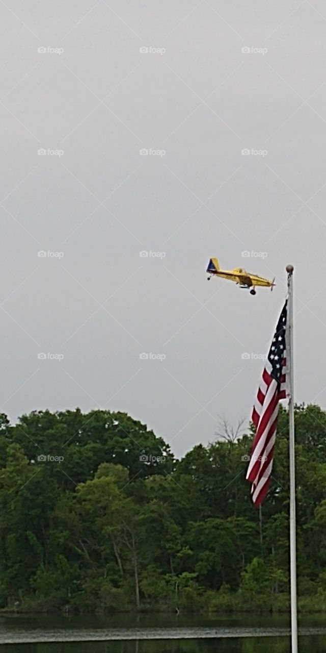 American Flag with a crop duster in background