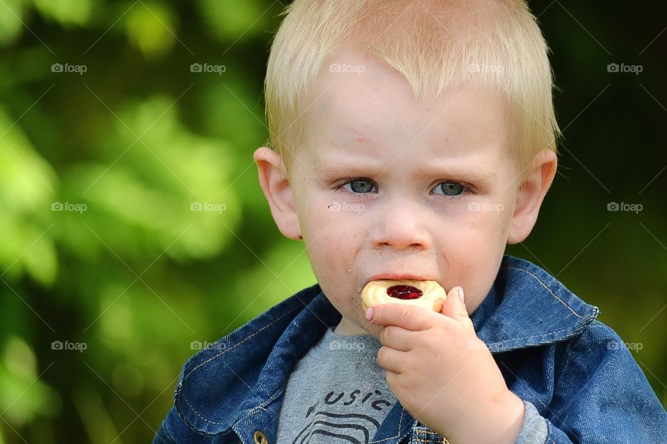 Cute boy eating cookie