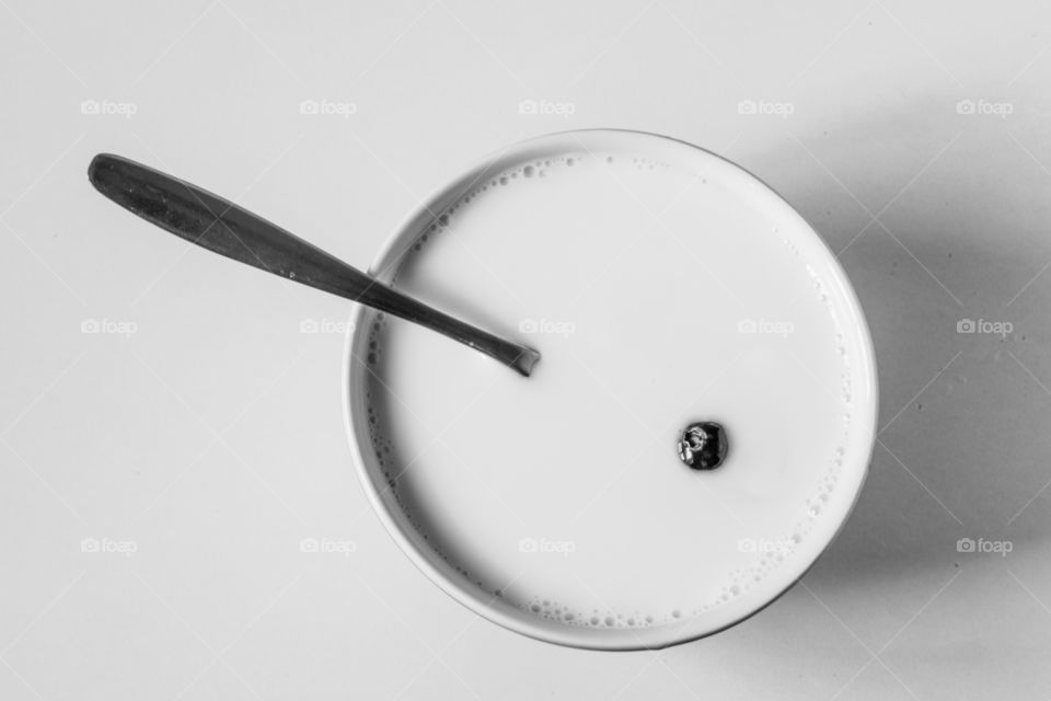 Blueberry floating in a bowl of milk