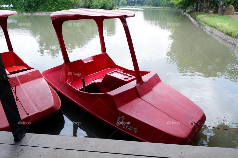 A boat that uses its legs to move in red floats on the water.