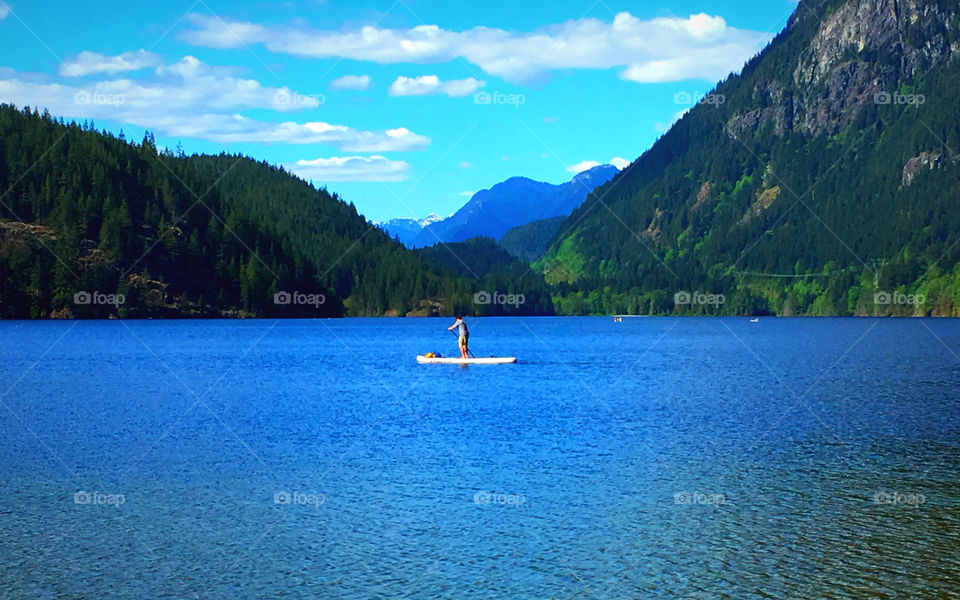 Remote lake, British Columbia. Canada, paddle boarder on wilderness lake