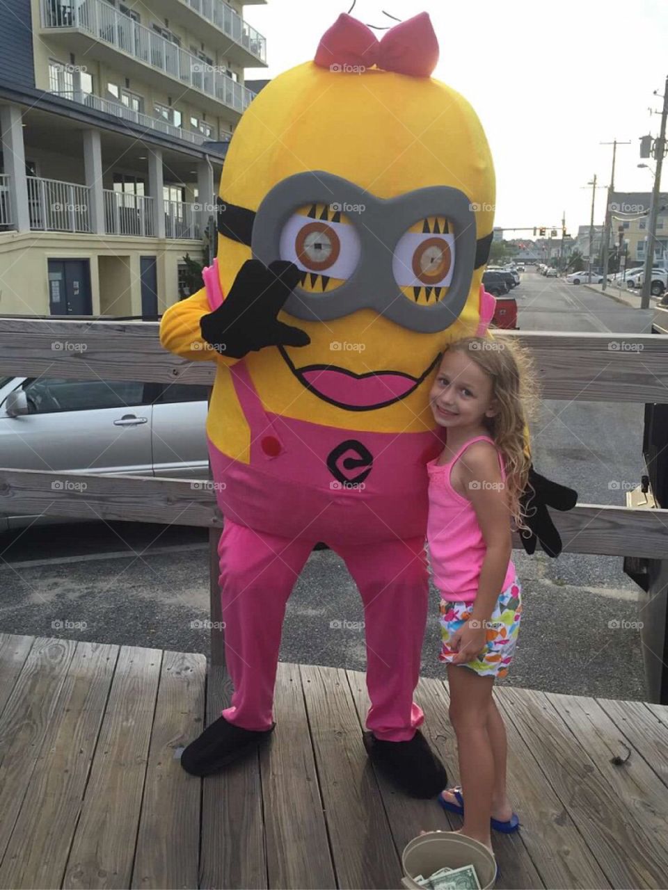 Little girl hugging a pink minion. 