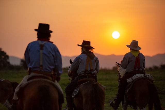man riding horse against sunset