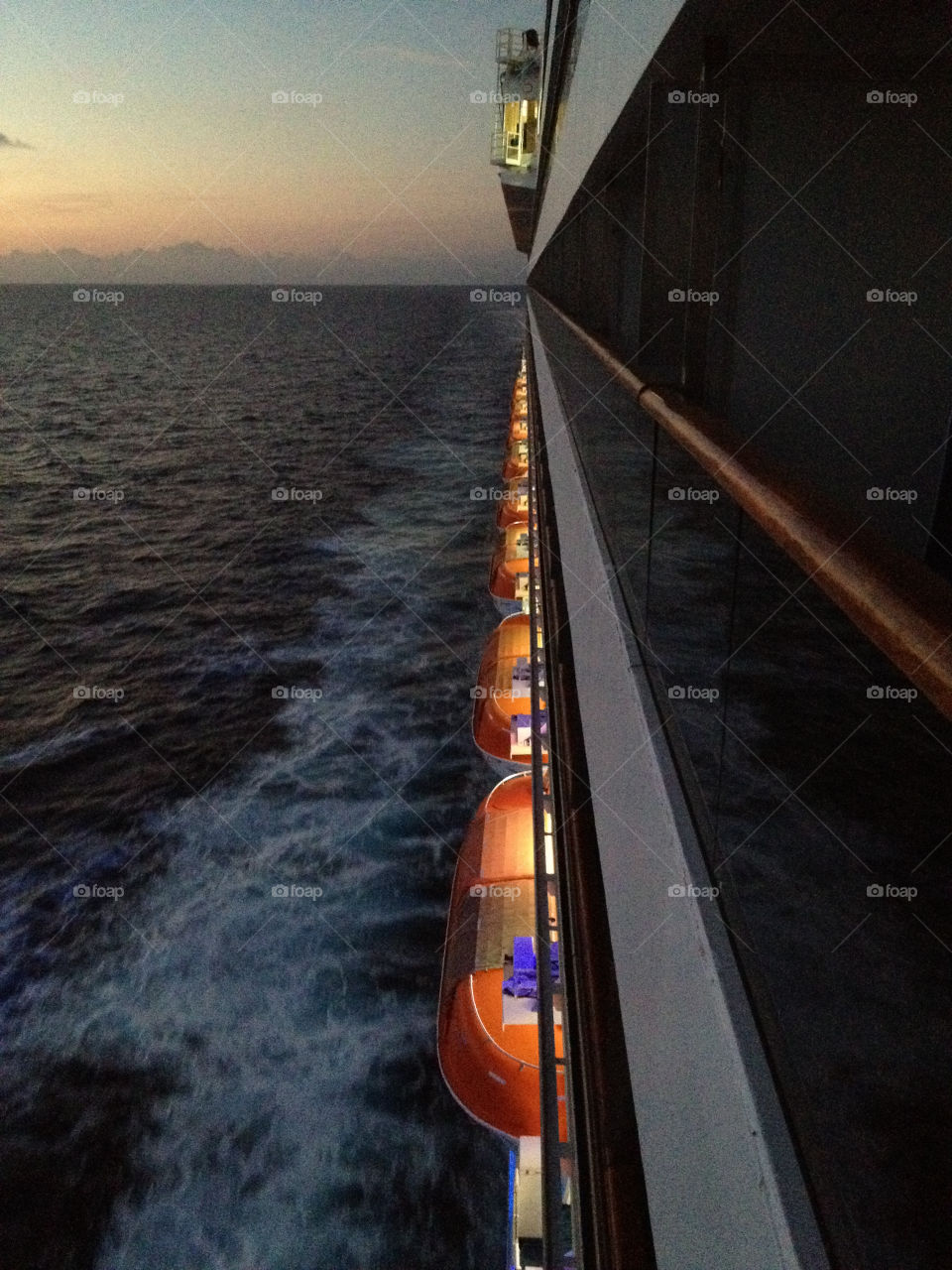 Cruise lifeboats at sunset