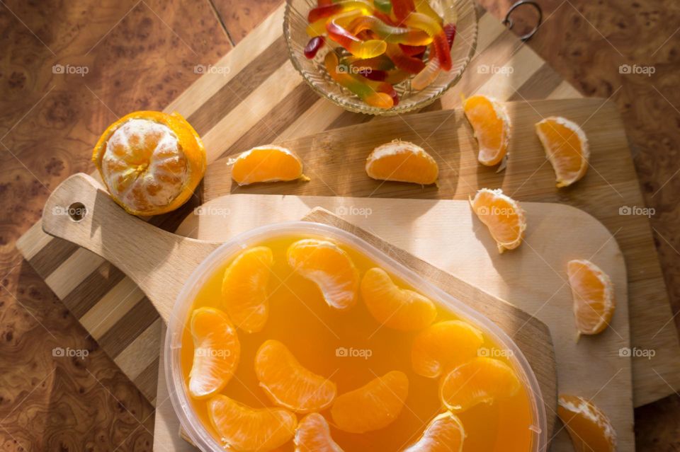 Delicious orange jelly with tangerine slices in a container and jelly worms.