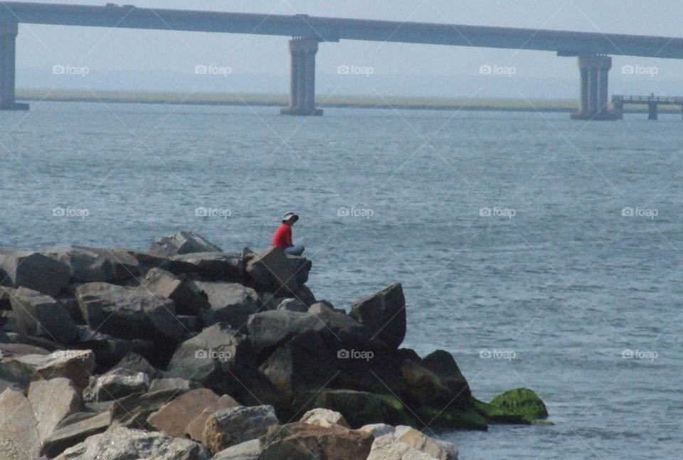 Man on Rocks by Ocean