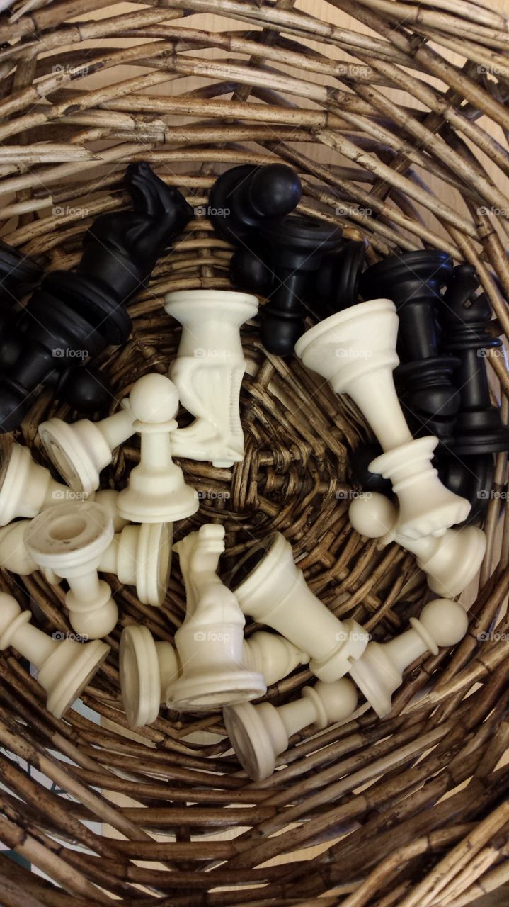 Black and white chess pieces in brown basket