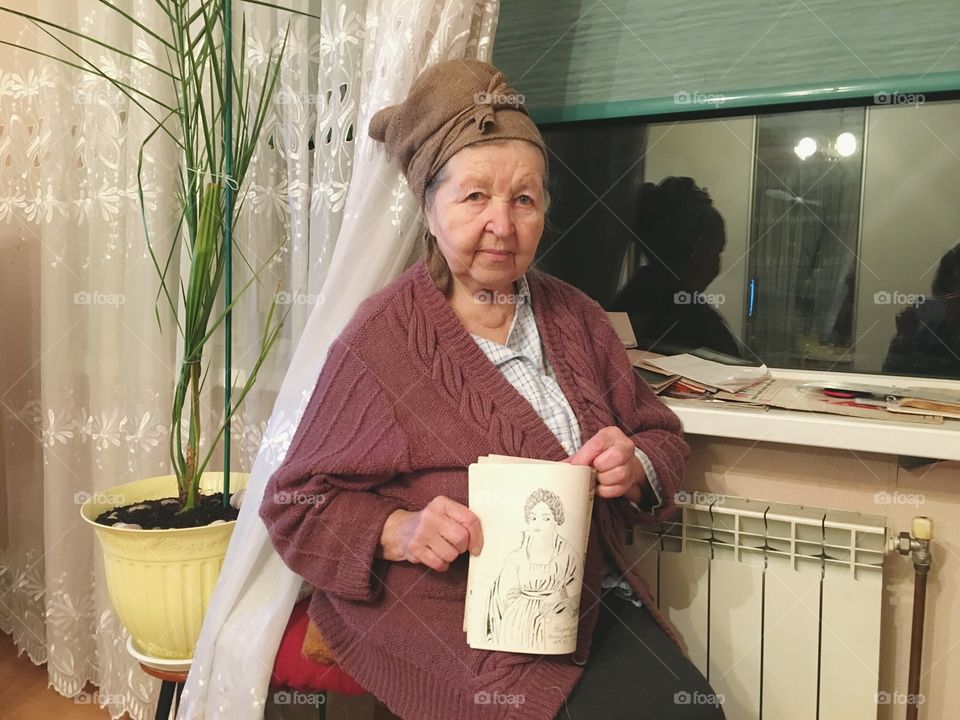 granny holding her paintings