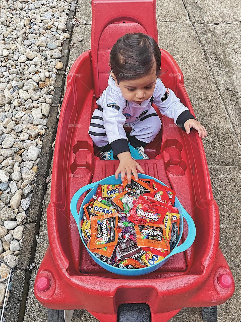 Baby dressed as astronaut reaches for Halloween candy, handing out candy on Trick or Treat night, beggars night festivities, little girl reaches for candy, baby girl excited about trick or treat 