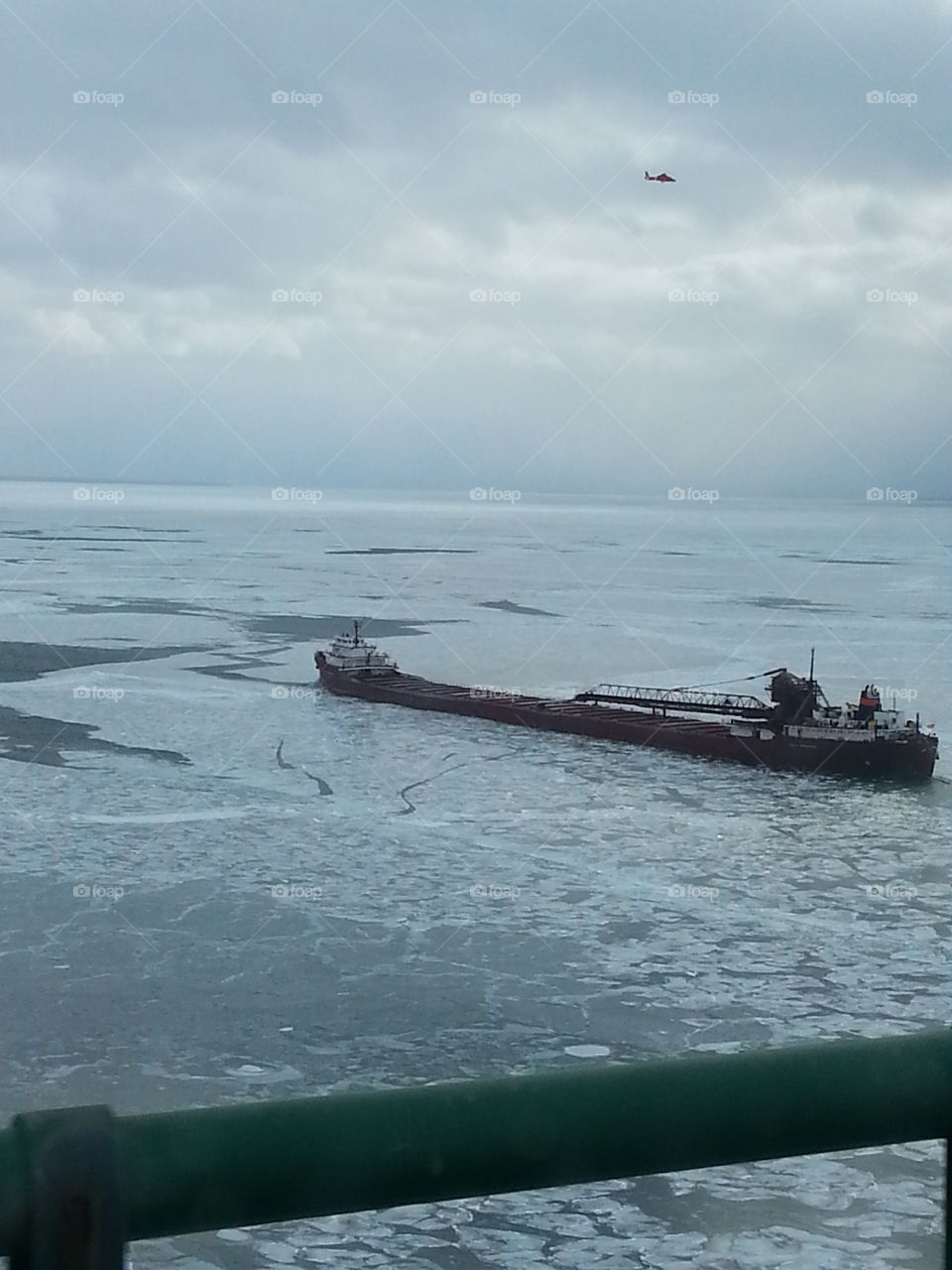 Stuck In The Ice. A freighter stuck in the Straits of Mackinaw. Notice the helicopter above. 