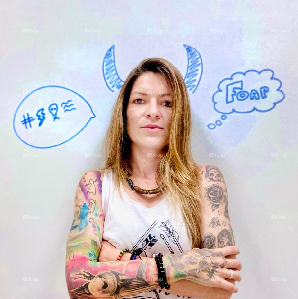 natural tattooed girl  With a blackboard background with drawings and horns. Foap
