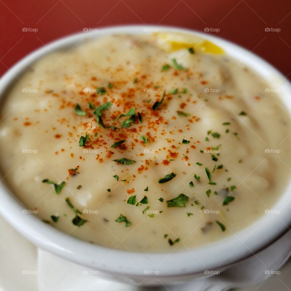 A cup of tasty and creamy hot clam chowder on the coast.