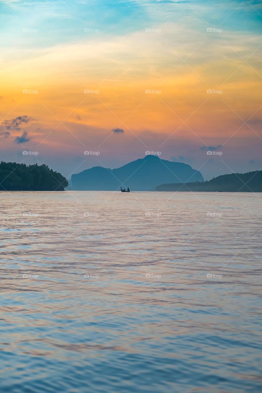 Beautiful Sunrise moment above silhouette of boat in sea