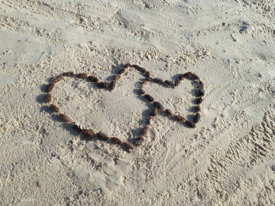 Two hearts on the sand beach. Romantic card