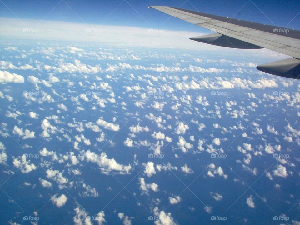 Above the Clouds. Looking down at the clouds flying over the Pacific Ocean on our way to Oahu Hawaii.