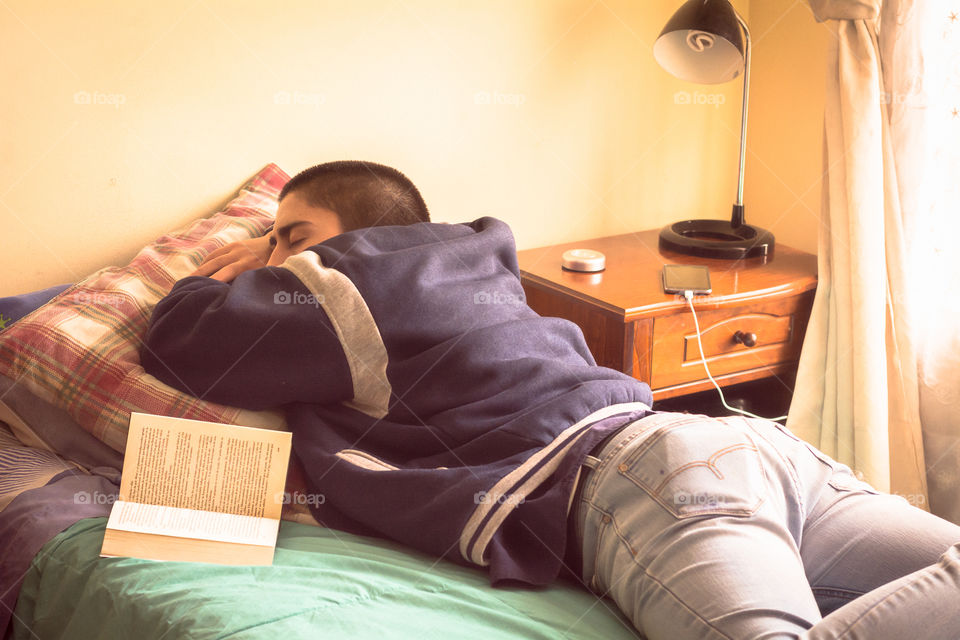 Young man sleeping after reading a book