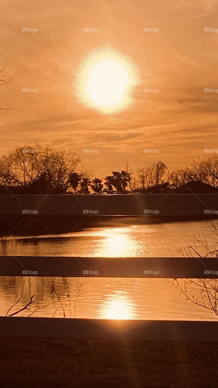 Evening Sunset high clouds spreading the sunbeams with the clouds. Evening colors appear strong for this early pic. Reflections of the Sunbeams / Rays off the lake waters.