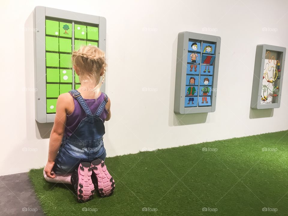 Young girl playing memory at a playground at a mall in Sweden.