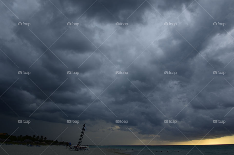 Storm cloud with rain over the sea during sunset
