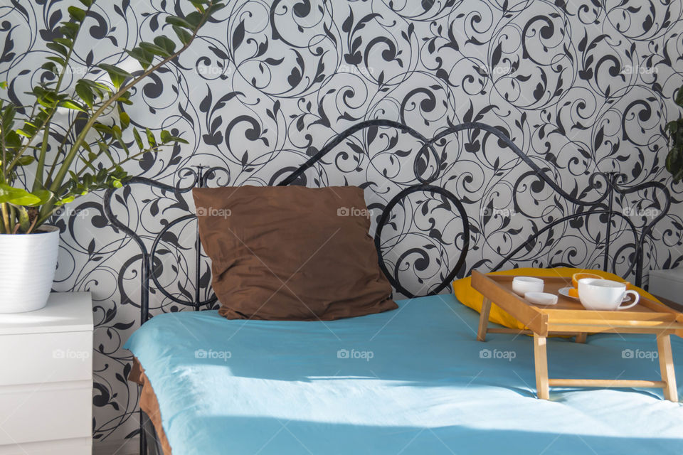 A man at home takes care of himself and does a manicure at home on a blue background and with orange.