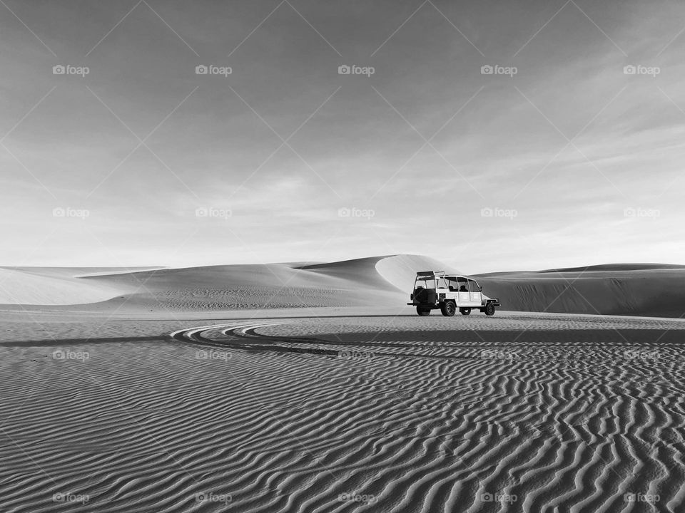 Car parked at the dunes during sunset